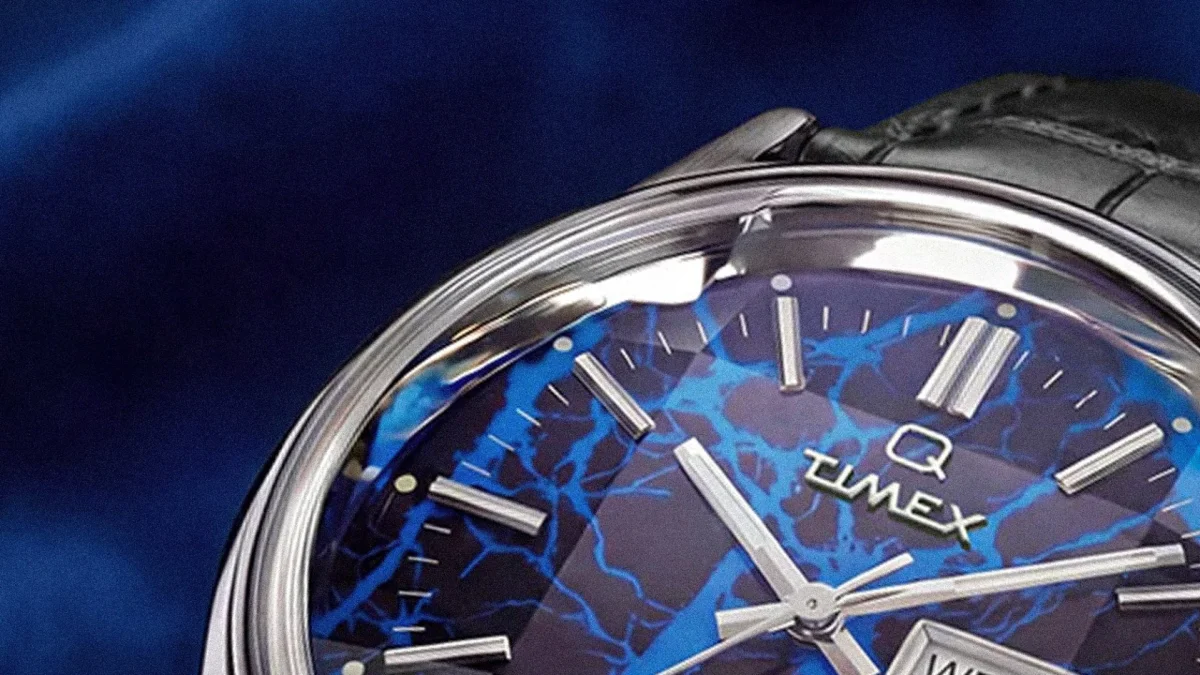 Close-up of a Timex watch face with blue and black marbled pattern and silver hour markers and hands.